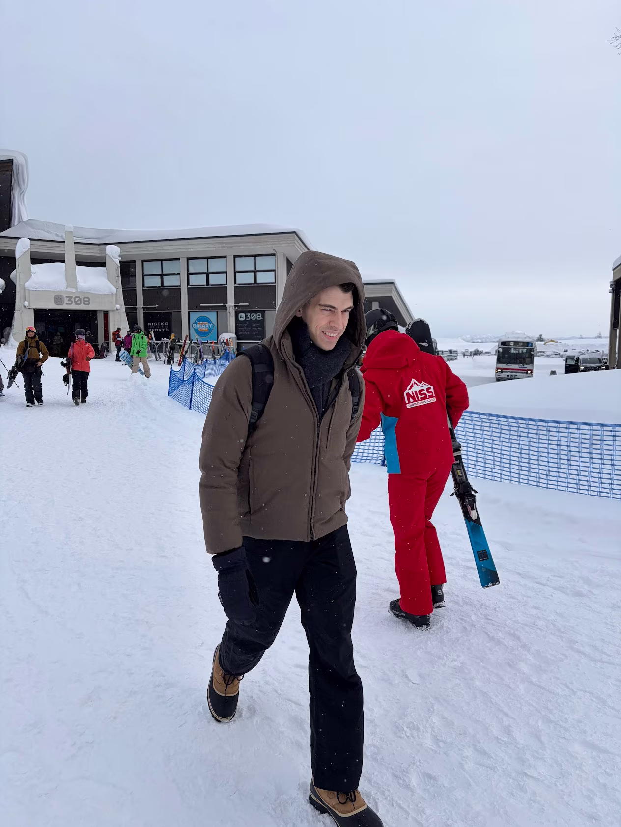 A photo of me walking through the snow in cold-weather gear, skiers and snowboarders in the background.